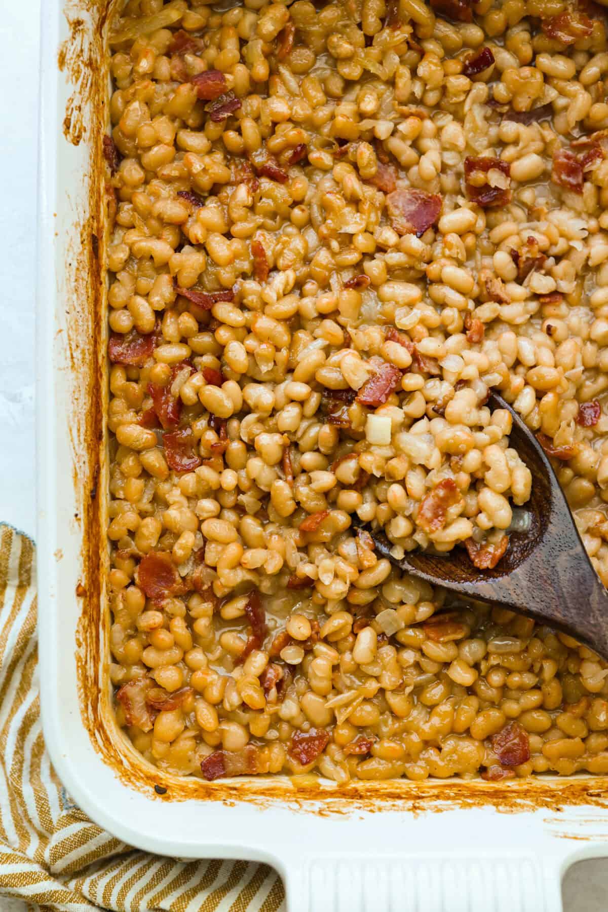 You're going to want this Copycat Grandma Brown’s Famous Baked Beans recipe in your life! It’s sweet, smoky, simple, and the perfect side dish for BBQs, summer cookouts, and every family get together. Overhead shot of Grandma Browns baked beans cooked in a baking dish.
