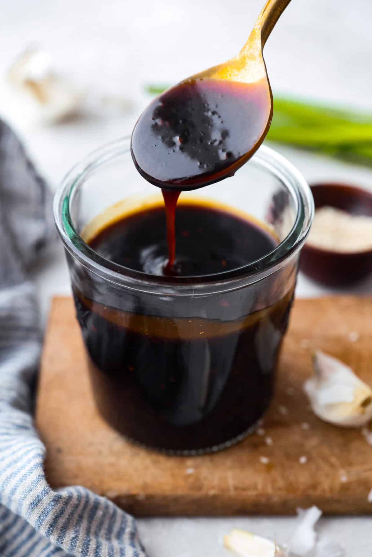Homemade teriyaki sauce is sweet, savory, and ready in just 10 minutes! It has the perfect thick, glossy texture and tastes incredible on chicken, salmon, vegetables, rice bowls, and more. Jar of homemade teriyaki sauce and someone dripping some from a spoon.
