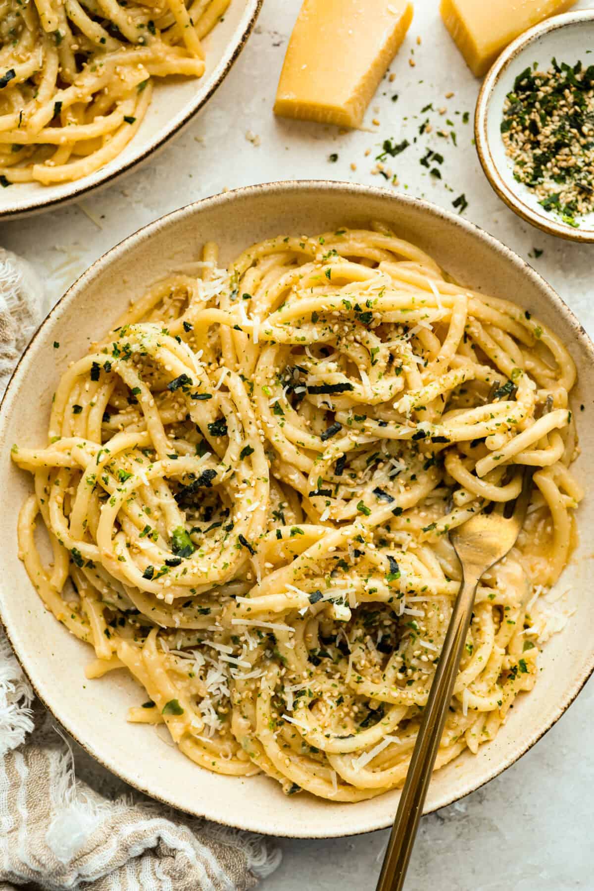 Bowl of miso pasta with gold fork.