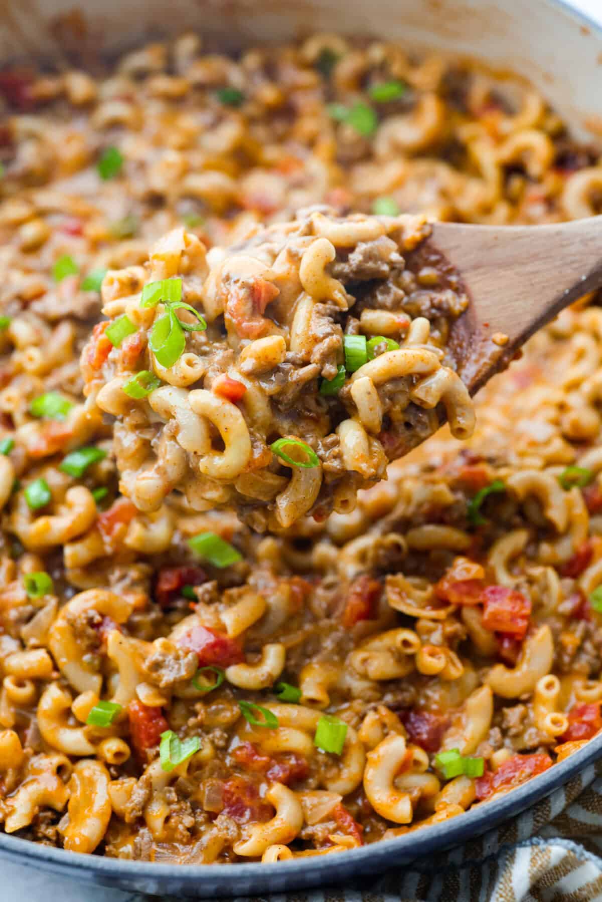 If your family loves tacos and mac and cheese, this one pan taco mac is about to become a weeknight favorite! It's cheesy, hearty, packed with Tex-Mex flavor, and comes together in one skillet in just 30 minutes. Close up shot of a scoop of one pan taco mac.