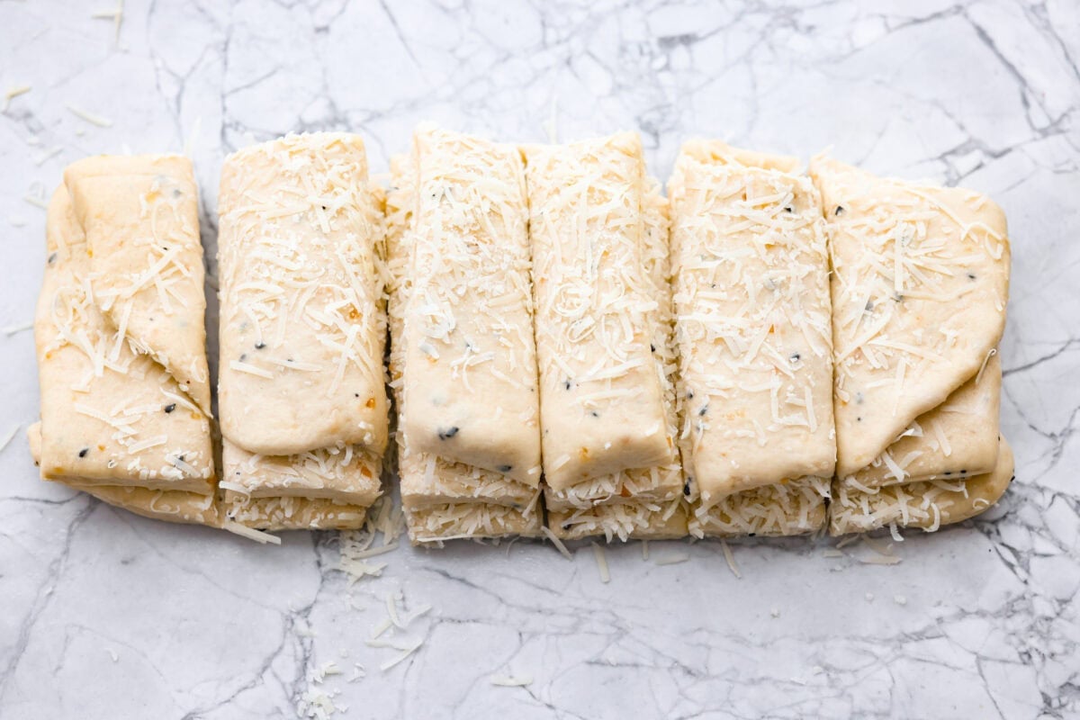 Everything bagel pull apart bread is soft, cheesy, and loaded with savory flavor in every layer. The homemade dough is stacked with Parmesan cheese and everything bagel seasoning, then baked until golden and fluffy. Dough sliced and stacked.