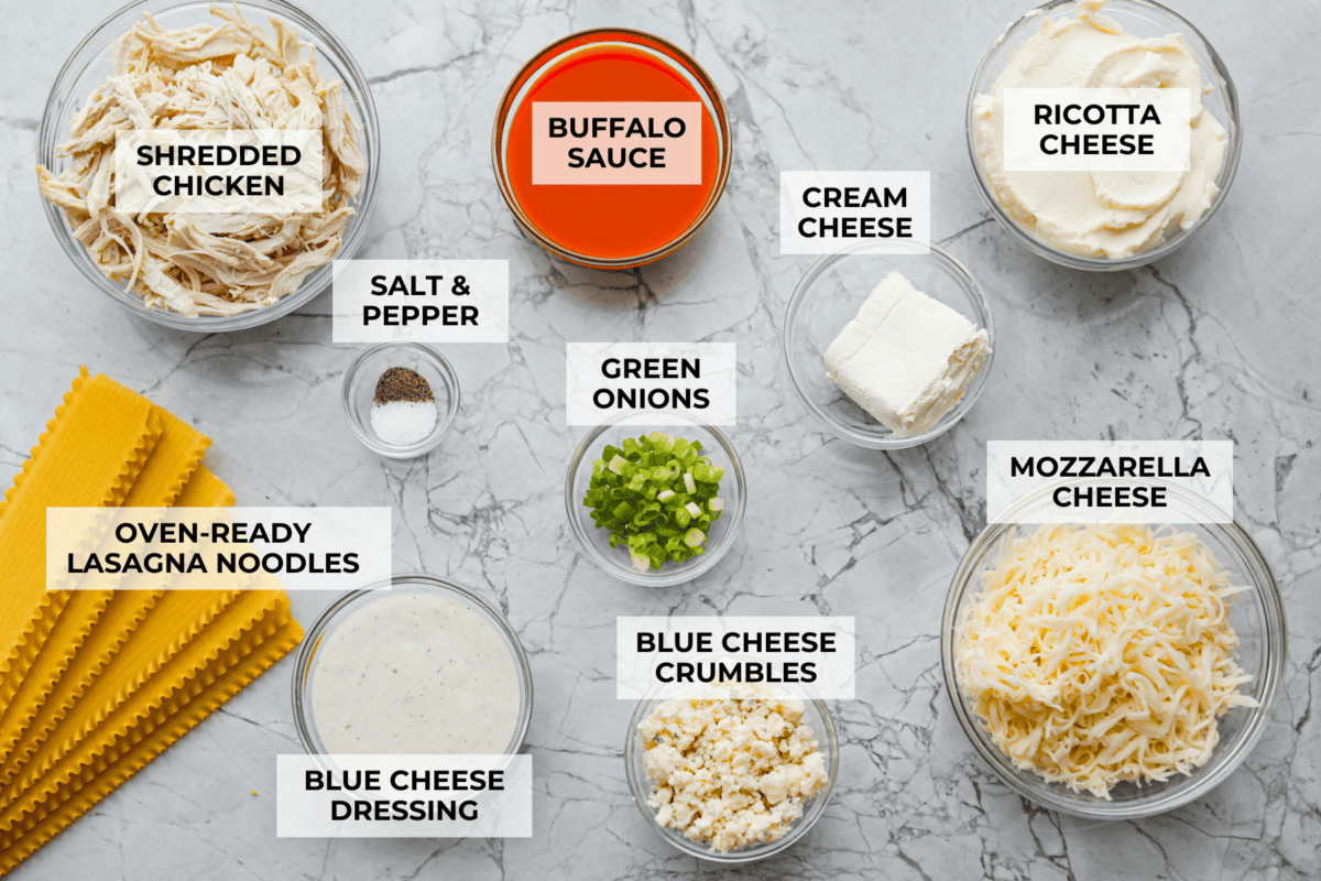 Take your lasagna night to the next level with this buffalo chicken lasagna! Every layer is packed with creamy buffalo sauce, tender shredded chicken, and plenty of melty cheese for a fun twist on a comfort food classic. Overhead shot of labeled ingredients.
