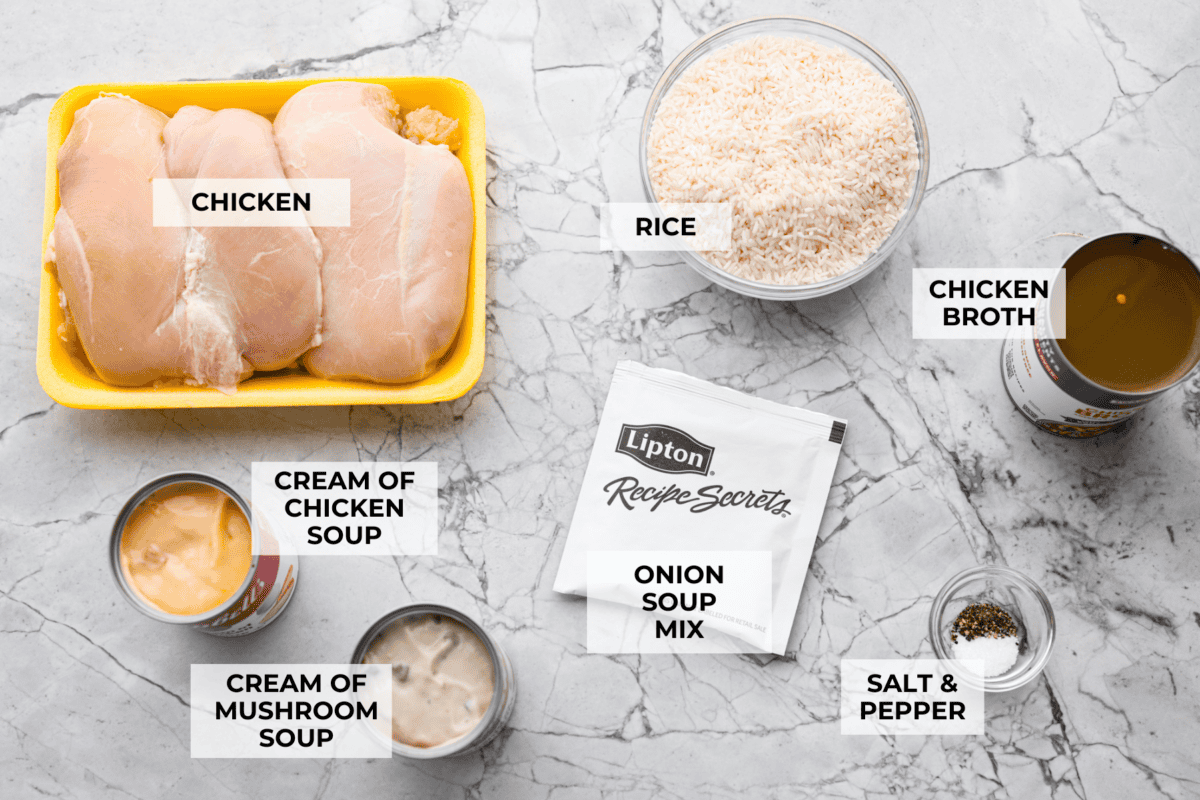 No peek chicken and rice casserole is the ultimate easy comfort food. Tender chicken and creamy, flavorful rice bake together in one dish. Just cover it tightly, pop it in the oven, and whatever you do, don’t peek! Overhead shot of labeled chicken and rice casserole ingredients.
