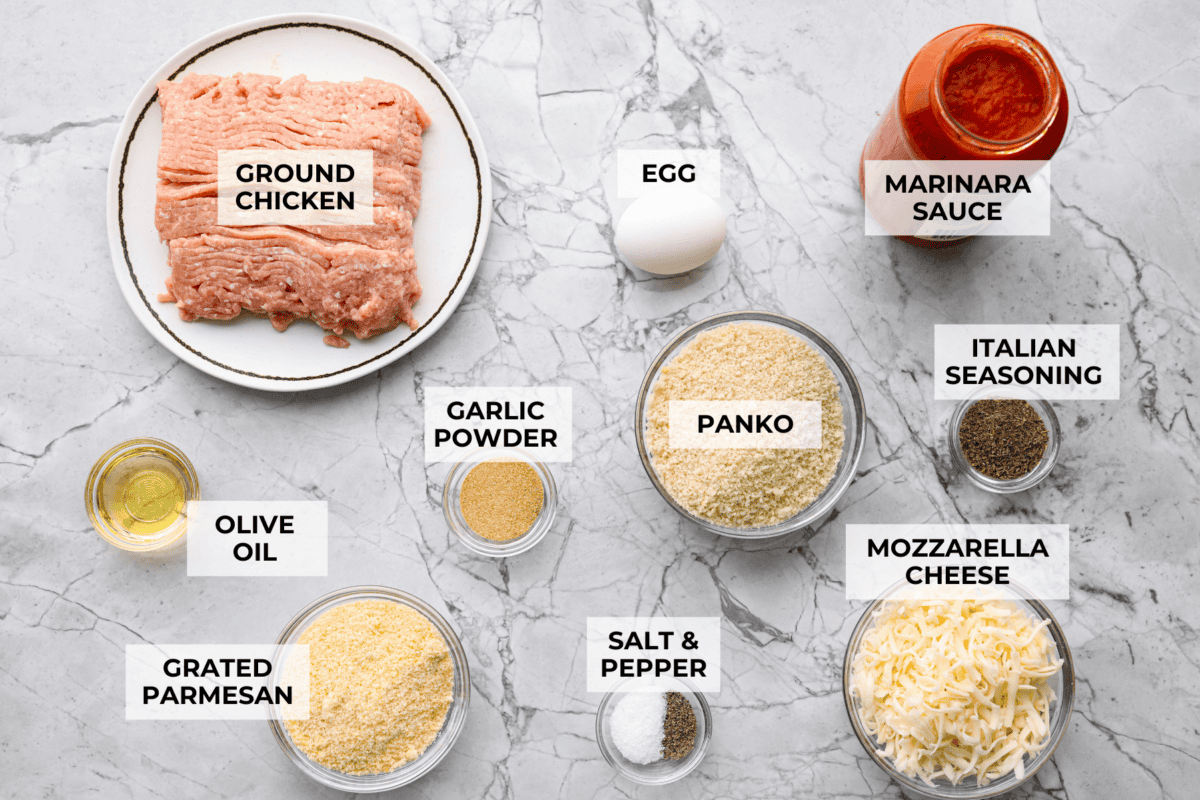 Chicken parmesan meatballs bring all the best parts of chicken parmesan together in one skillet. Think tender chicken meatballs, crispy Parmesan breadcrumbs, saucy marinara, and lots of melted mozzarella. Overhead shot of labeled chicken parmesan meatballs ingredients.