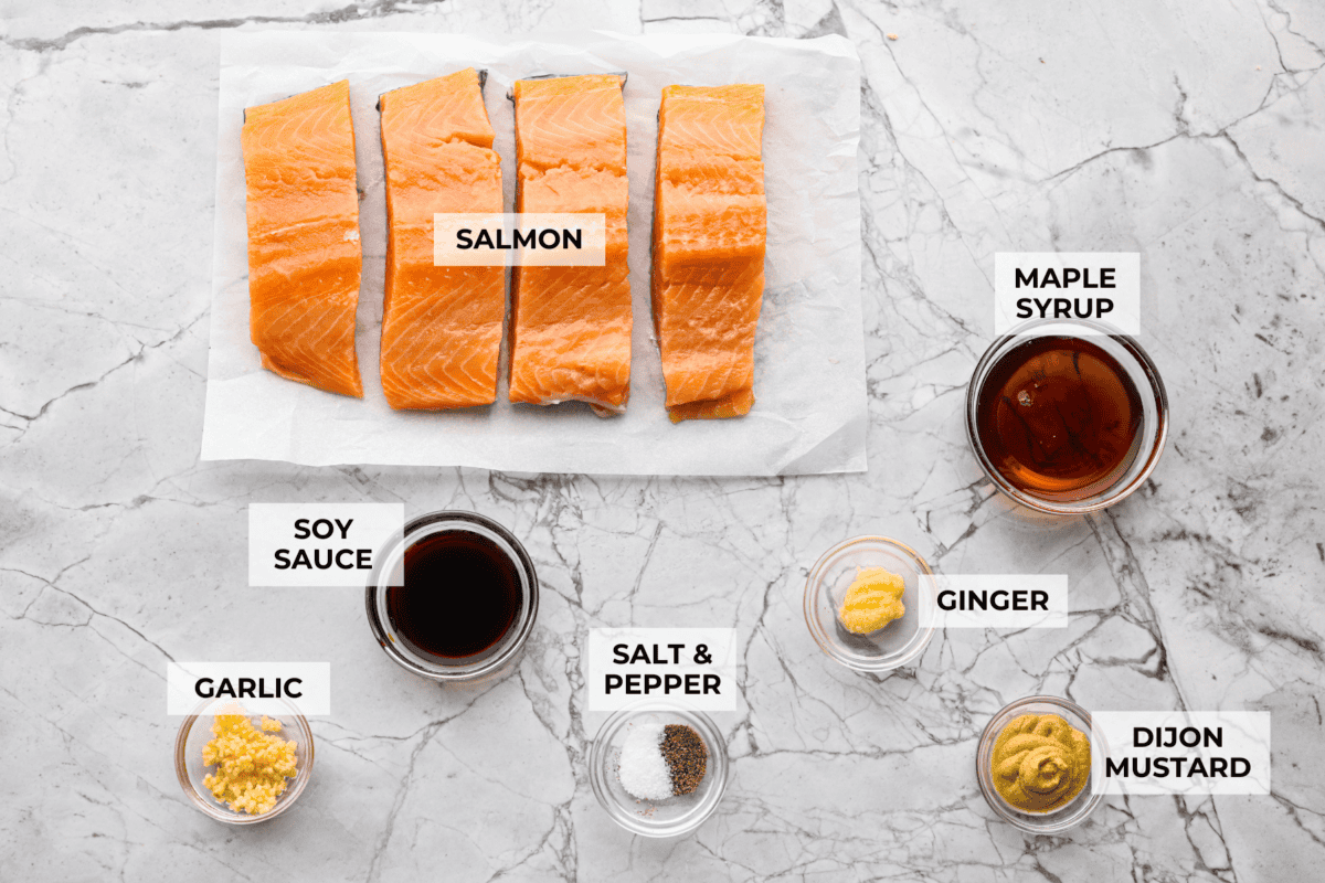Maple glazed salmon has that perfect sweet-and-savory flavor that keeps you going back for just one more bite. As it bakes, the maple glaze turns glossy and caramelized while the salmon stays buttery, flaky, and melt-in-your-mouth tender. Overhead shot of labeled ingredients.