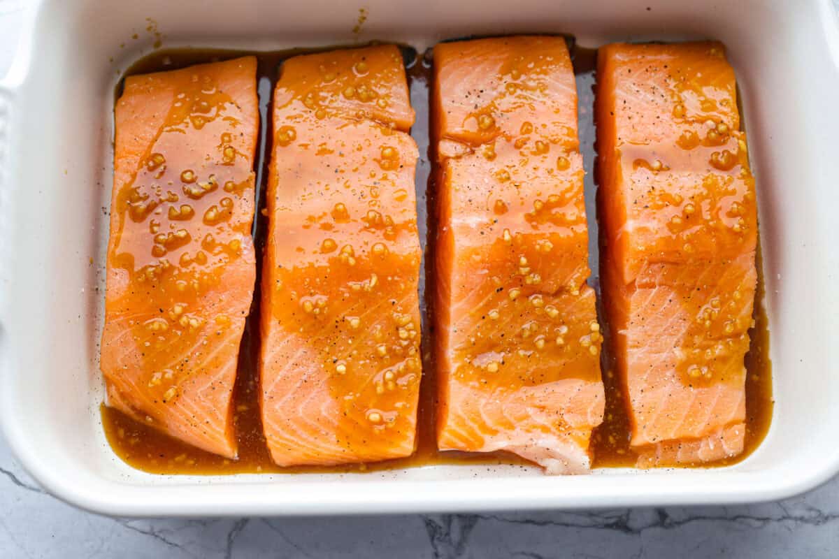 Maple glazed salmon has that perfect sweet-and-savory flavor that keeps you going back for just one more bite. As it bakes, the maple glaze turns glossy and caramelized while the salmon stays buttery, flaky, and melt-in-your-mouth tender. Sauce poured over the salmon ready to be cooked.