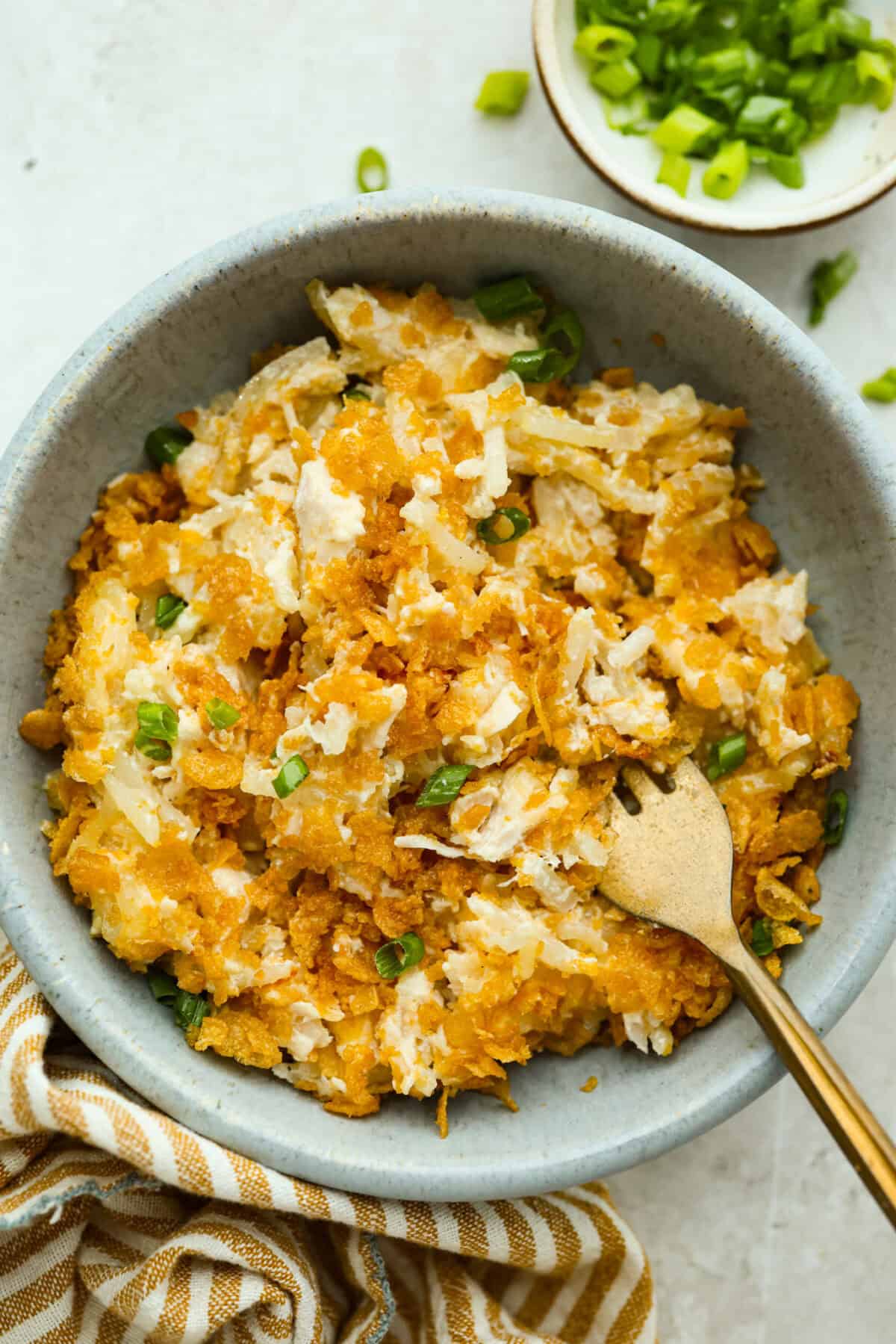 My funeral potato and chicken casserole turns the classic cheesy side dish into a complete dinner. It’s creamy, comforting, and packed with tender chicken, potatoes, and plenty of cheese. Bowl with a serving of funeral potatoes and chicken casserole.